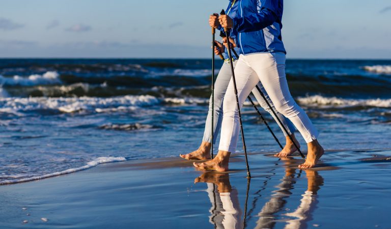 Jastrzębia Góra nocleg – dwie kobiety uprawiające nordic walking na plaży