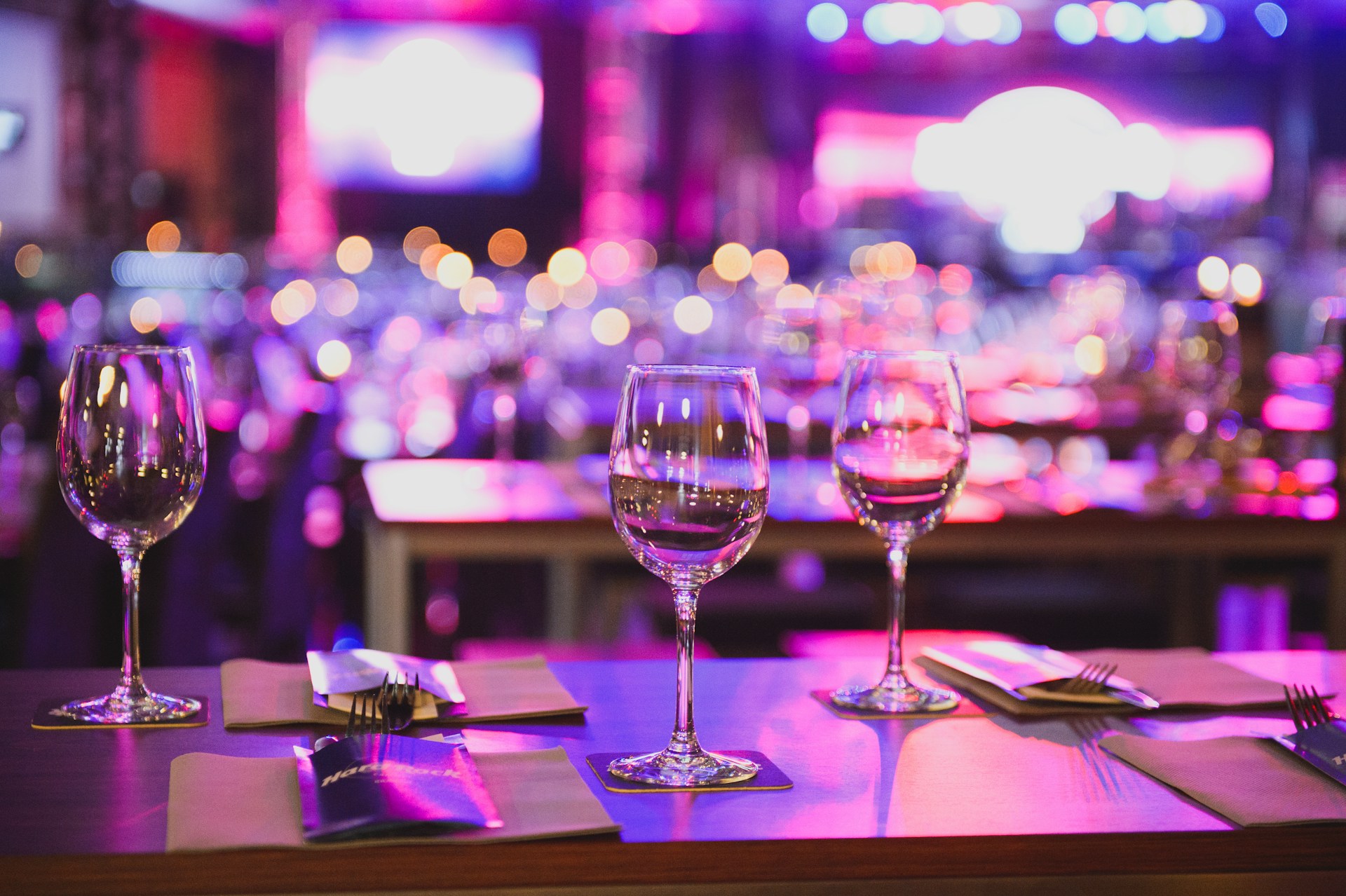 Organizacja firmowego jubileuszu – elegancko przygotowane stoły i kieliszki podczas wydarzenia firmowego w restauracji.